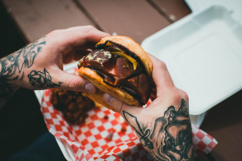Man with tattoos holding a burger