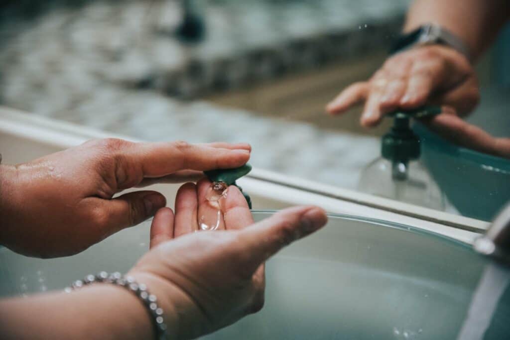 Person washing hands in sink