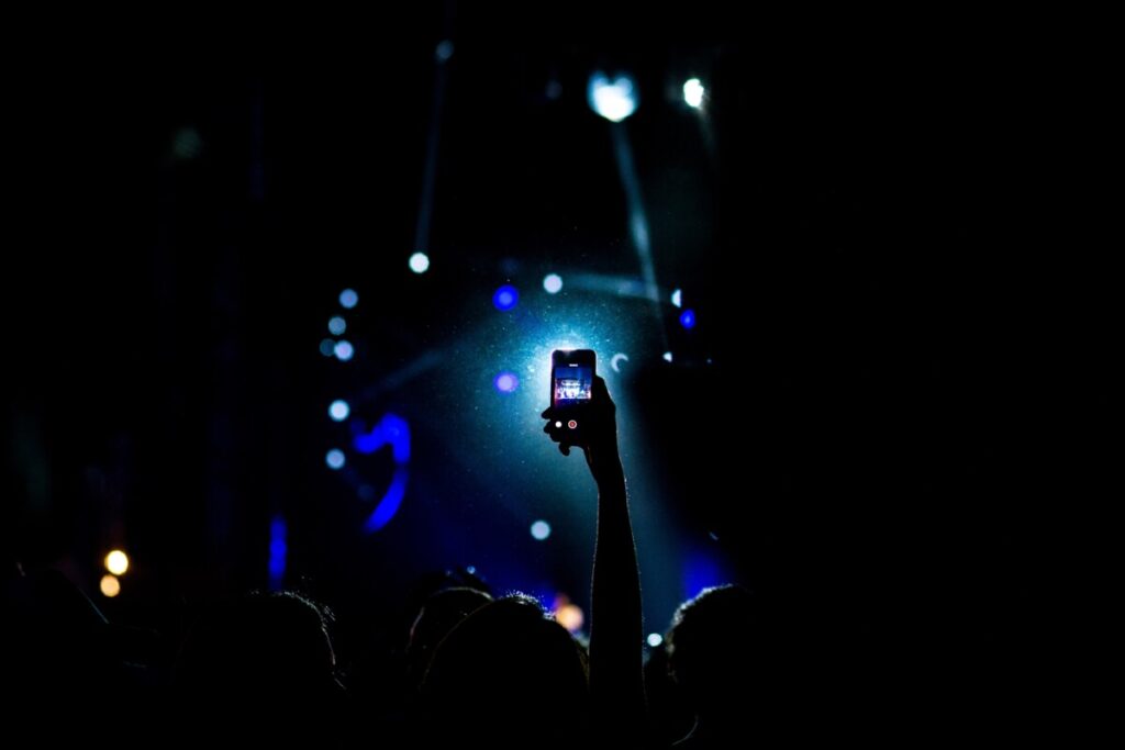 Hand holding phone at a concert