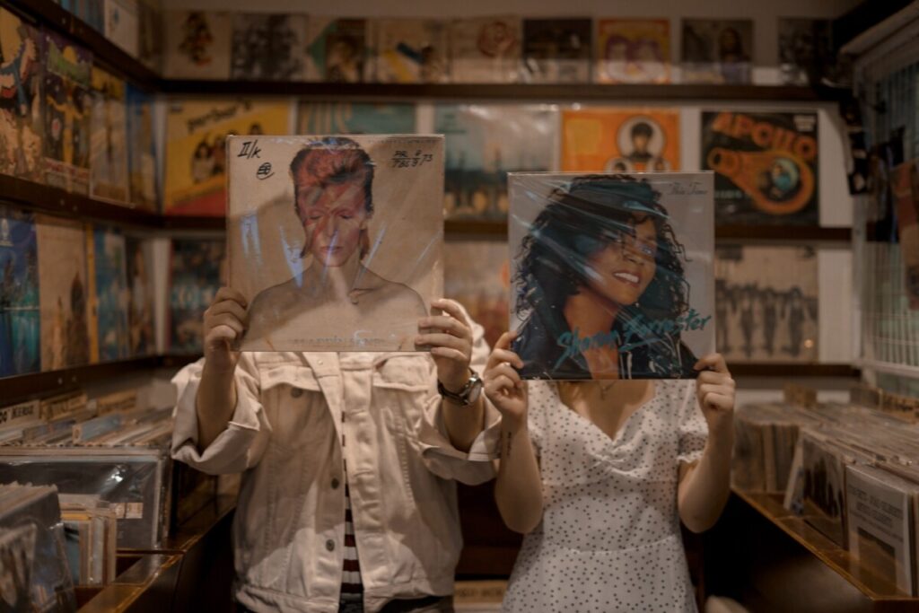 Two people holding vinyl records