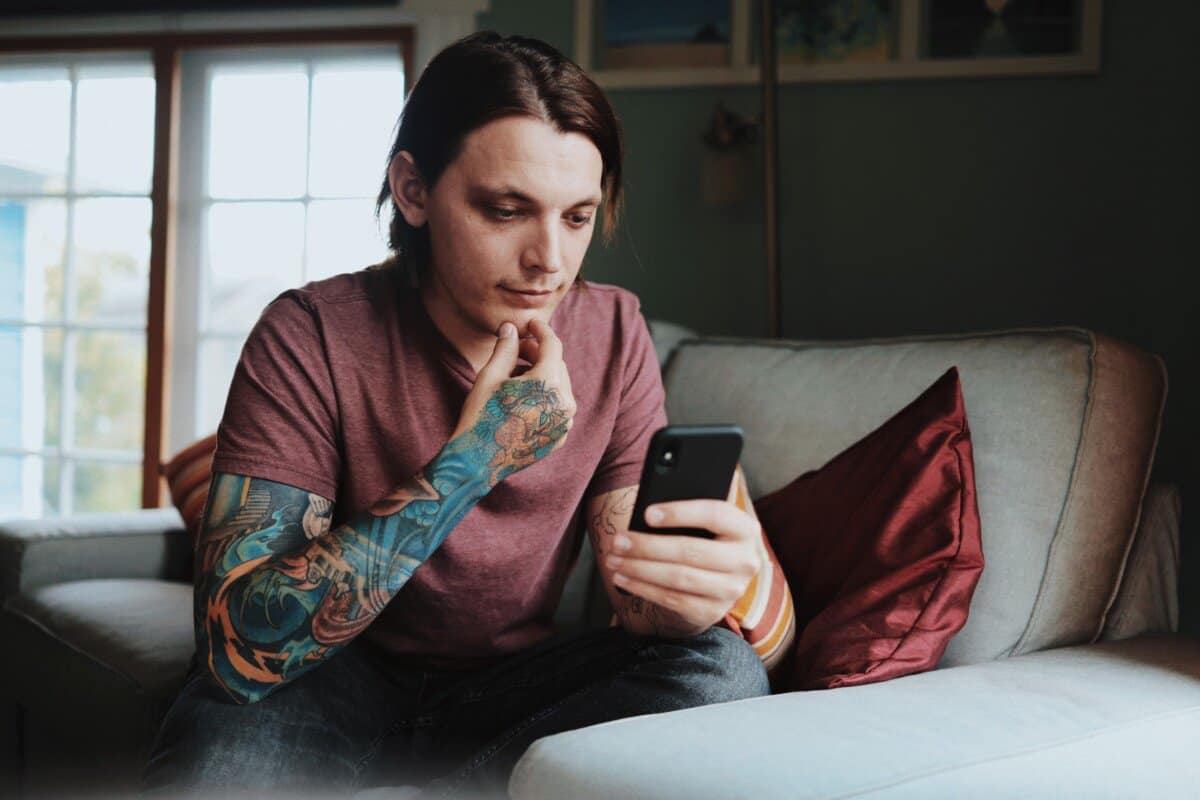 Man with tattoos looking at his phone
