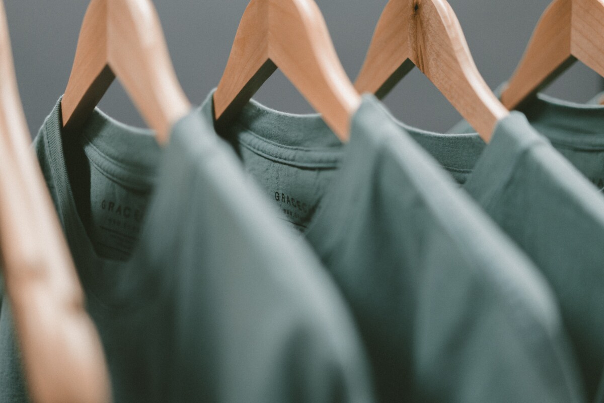 Green shirts on wooden hangers