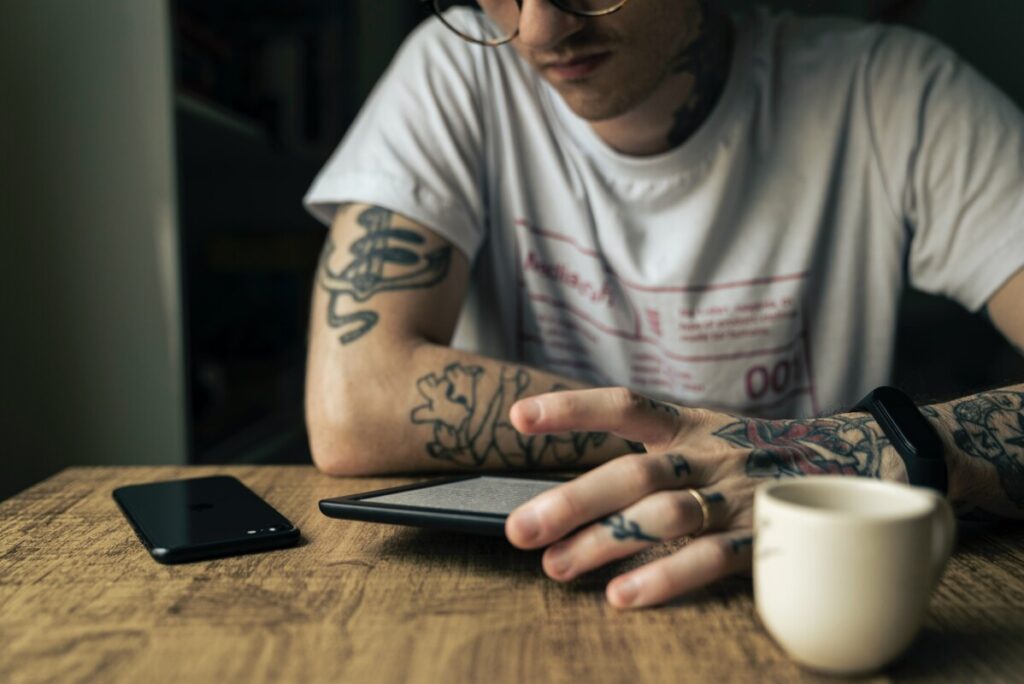 Man with tattoos reading a tablet