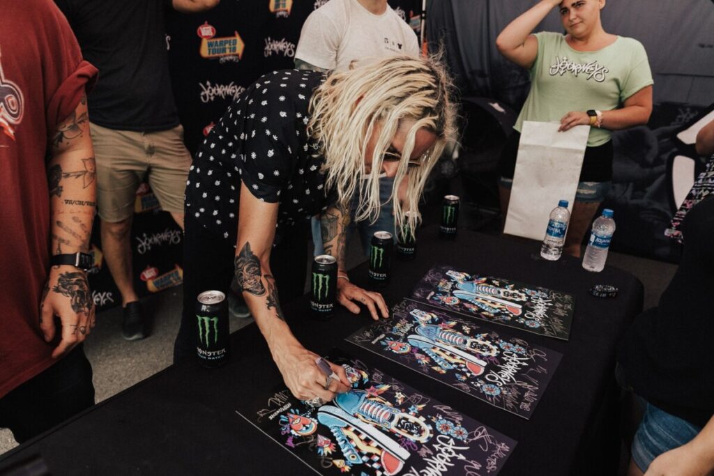 Spencer Chamberlain of Underoath signing a poster